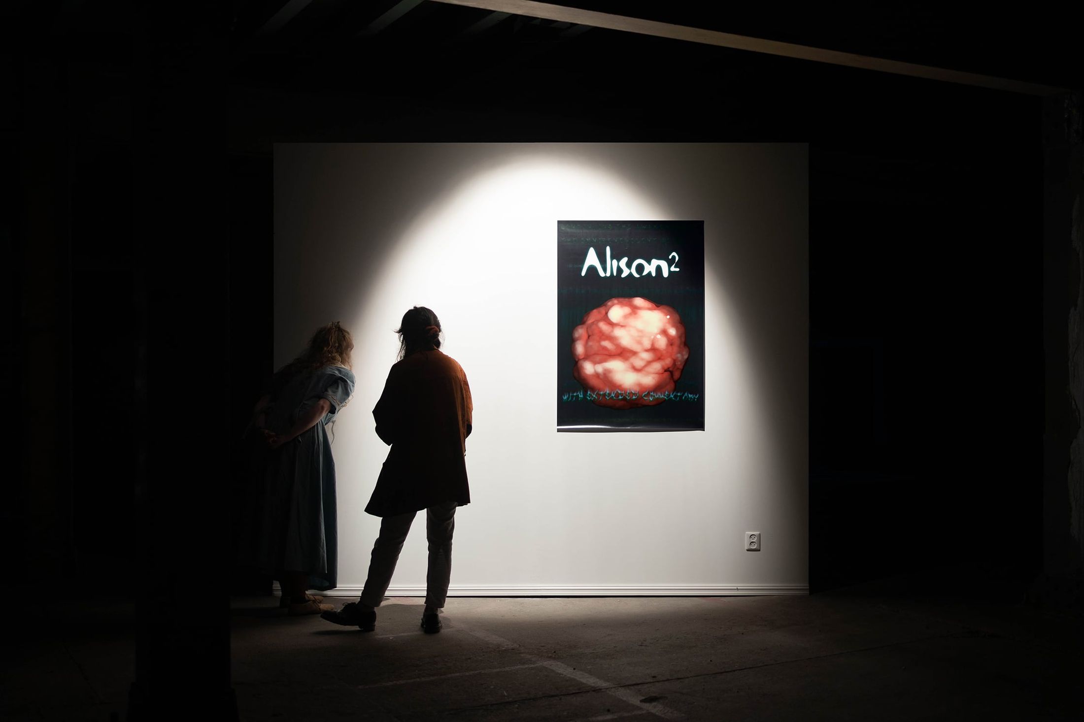 Two people are looking through the spyhole of Invisible Wall (2021) by Melle Nieling